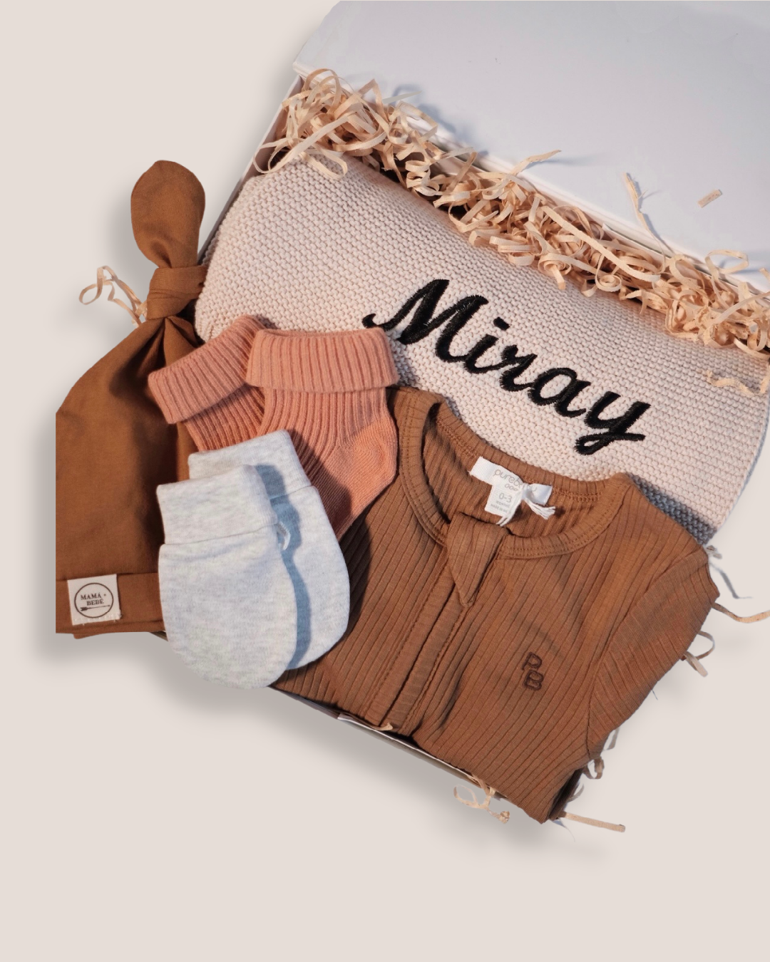 colour:chocolate | Close-up of chocolate welcome baby gift set with personalised Miray knit blanket