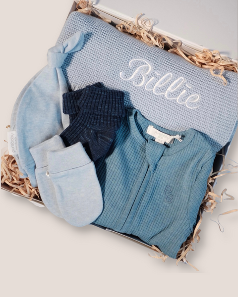 colour:lake-blue | Close-up of lake blue welcome baby gift box with personalised BILLIE knit blanket