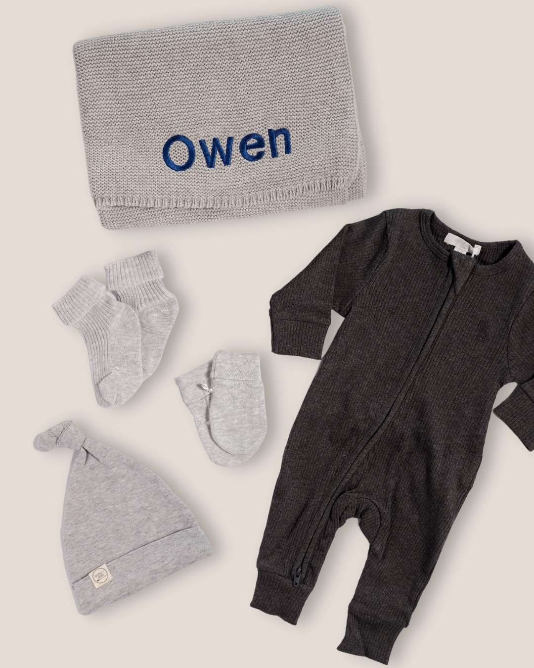 colour:charcoal | Flat-lay of personalised charcoal welcome baby gift set