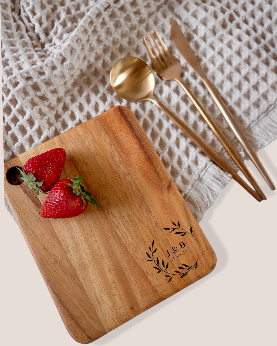 Personalised acacia cheeseboard with J&B wreath engraving styled with strawberries and rose gold cutlery – wedding gift Australia