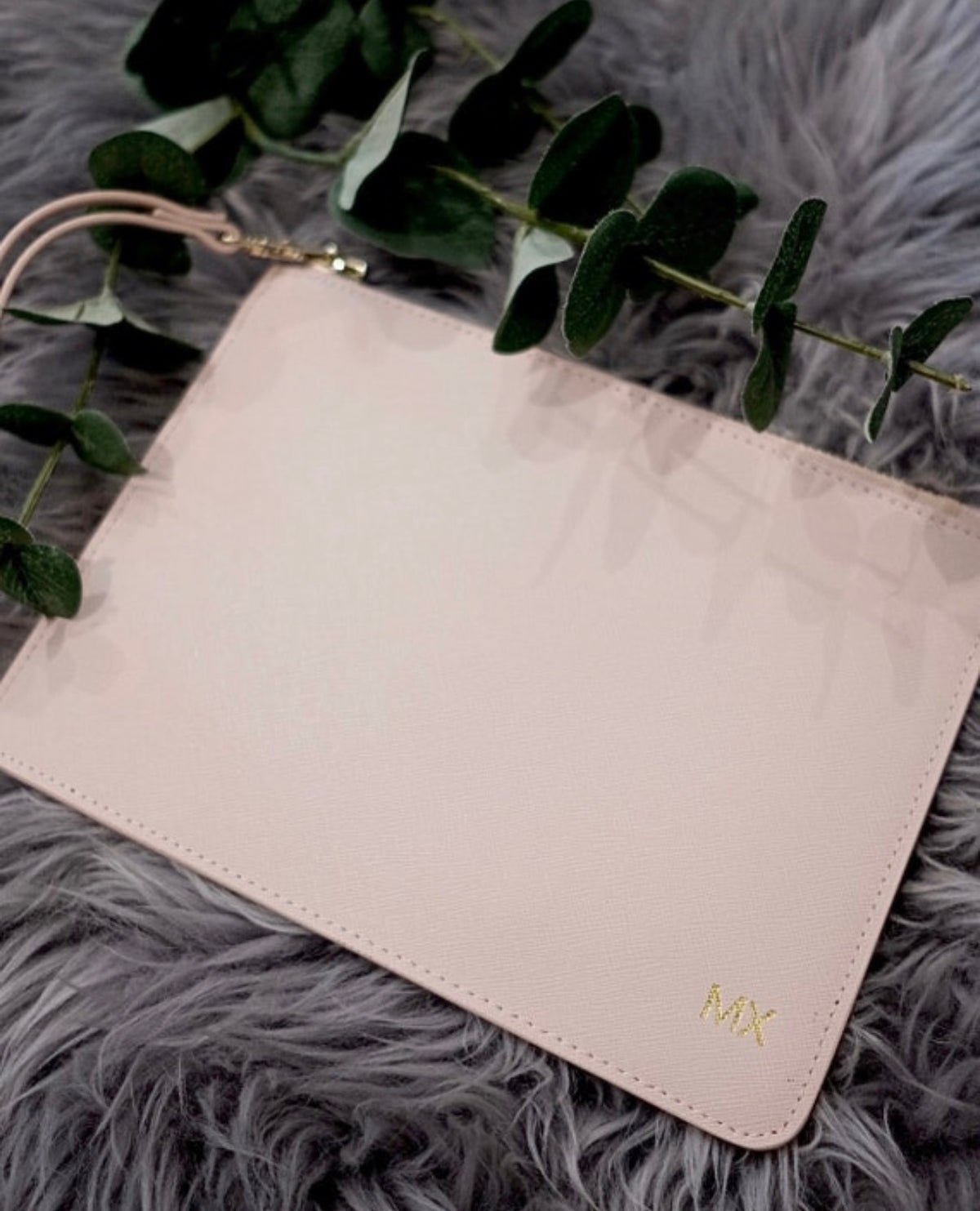 Close-up of personalised monogrammed leather clutch with gold MX initials engraving – custom bridesmaid gift Australia