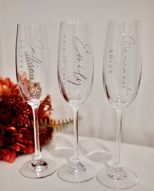 Three personalised engraved champagne flutes upright with bridal party roles Bridesmaid, Maid of Honour and Bride – wedding gift Australia